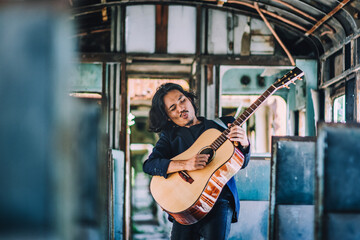 Fototapeta na wymiar Man playing guitar rock so excited music entertainment , man play guitar on train