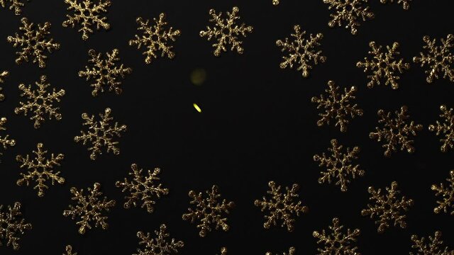Christmas holiday background, gold snowflakes with glitter particles on black