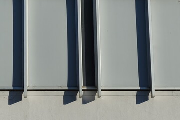 Wall with stainless steel bars and afternoon shadow.