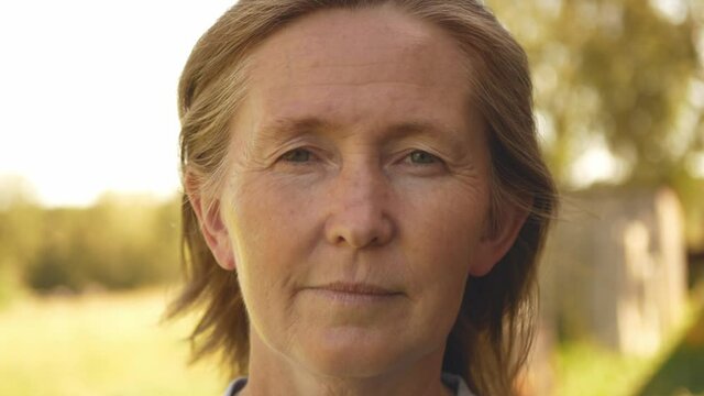 Close up view on mature woman with red hair. Close up view on old woman with wrinkles on face. Portrait of adult person with freckles on face. Natural beauty.