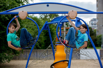 Children, playing on a playground, hanging in big circles on a climbing structure