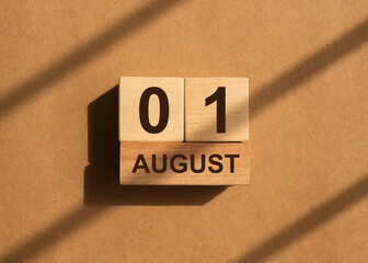 1 August on wooden cubes on craft background.