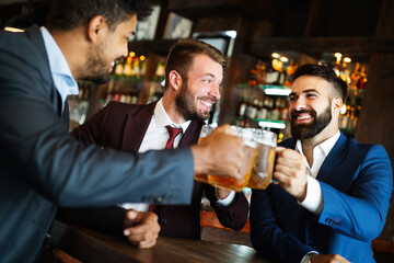 People, men, leisure, friendship and celebration concept. Happy male friends drinking beer at pub