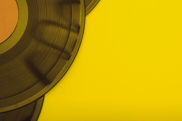 old vinyl records on a yellow background close-up
