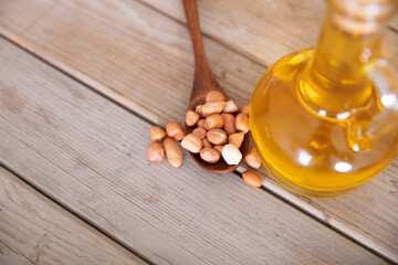 A spoonful of peanuts and a bottle of peanut oil