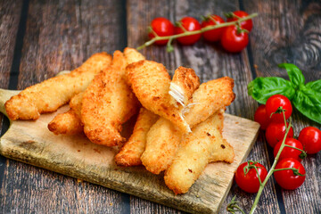 
 Crispy  deep fried home made    chicken strips Breaded  with  almond flour chicken  breast fillets  with chilly peppers and fresh   basil on wooden rustic background. Ketogenic diet food