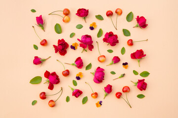 Flat lay, copy space. Summer composition with  flowers, leaves and berries sweet cherry on a beige background.