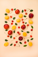Flat lay, copy space. Summer composition with  berries sweet cherry, apricots, peaches on a beige background.