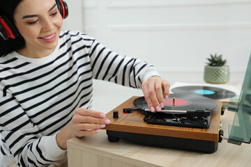 Fototapeta na wymiar Woman listening to music with turntable at home