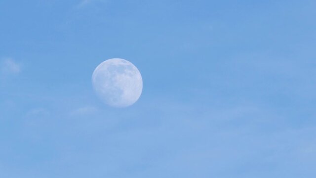 Blue sky on daytime with a half of the moon. Close up and soft focus. rising moon