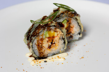 Avocado sushi roll served on a white plate