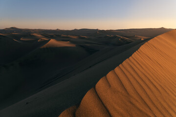 Obraz na płótnie Canvas Scenic sunset in the desert full of sand dunes. Ica, Peru