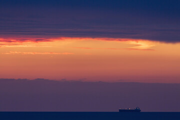 Sunset over the Irish Sea from Penmaenmawr, Wales with a silhouette containers ship on the horizon. Concept is Peace and serenity