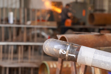 Pipeline. Electric gas welding. Butt weld seam of welding the pipeline DN50 to the bend and the pipe against the background of sparks from stripping the seam. Oil and gas pipeline.