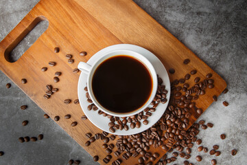 Cup of coffee and coffee beans on old wooden background
