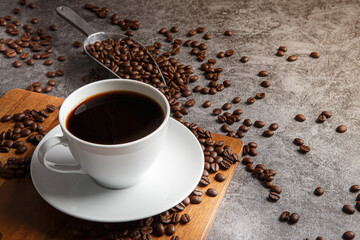 Cup of coffee and coffee beans on old wooden background