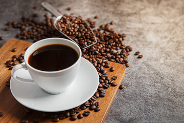 Cup of coffee and coffee beans on old wooden background