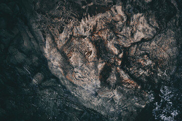 Water Ripples and Swirls. Polished and worn stone surface closeup abstract texture background. Abstract black-brown background of stone underwater.
