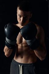 boxer in black gloves on a dark background inflated torso bodybuilder fitness
