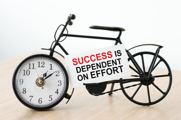 Text Success is dependent on the effort of the card next to the watch on a light background