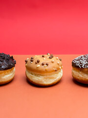 Delicious glazed chocolate donuts on vibrant background