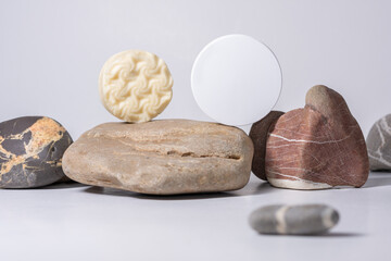Skin care, body care products (soap and solid shampoo) and packaging with a place to copy against the background of stones with a selective focus. The concept of spa and natural skin care.