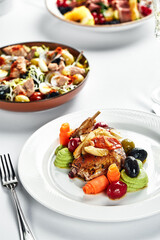 Quail stewed with vegetables on a festive table with white tablecloths, wedding table with quail appetizers