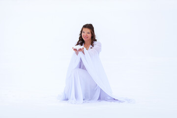 Fototapeta na wymiar Woman in white dress in winter on the snow romantic image