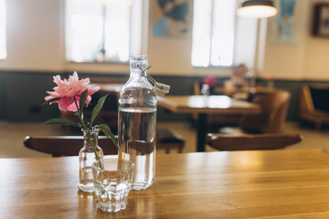 Flower in vase with bottle of water in cafe