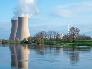 Nuclear power plant against sky by the river at sunset