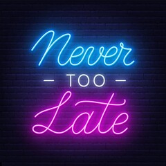 Never Too Late neon quote on a brick wall.