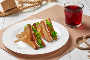 Toasted bread sandwiches with ham, cheese, tomatoes, lettuce and compote