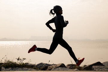 Fitness woman running on winter coast
