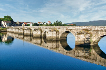 Fototapeta na wymiar Reflejo del puente medieval de Ponte Sampaio sobre el agua del río Verdugo en la provincia de Pontevedra, España