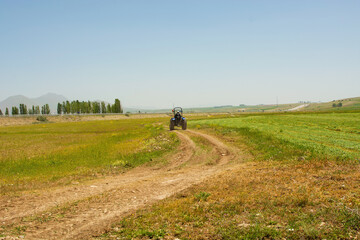 back photo of tractor driving off-road.