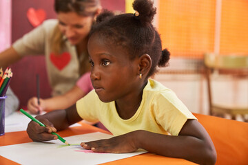 African girl painting picture in preschool