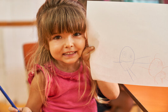 Girl proudly shows a creative drawing