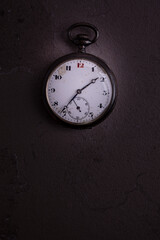 Old pocket watch on dark background with copy space