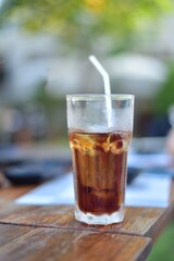Water in glass on wood table.