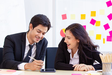 Asian and caucasian ethnicity partnership businesspeople discuss a business plan together