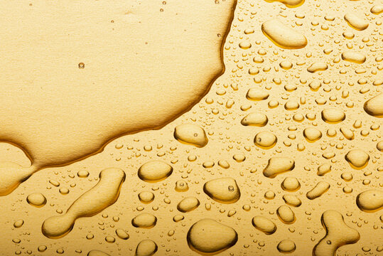 Drops on a gold background. A spray of moisturizing spray from above
