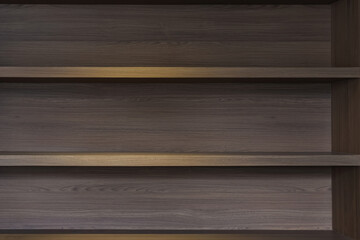 empty space of built in wooden shelf at wall with down-light