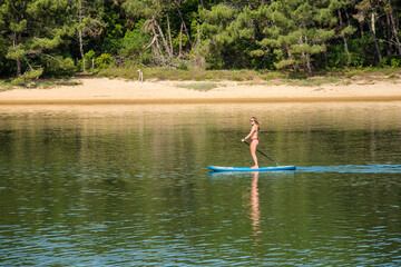 Fototapeta premium young sporty woman paddling in bikini on a lake 