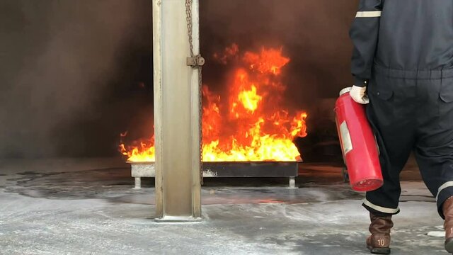 Fireman extinguish fire with CO2 extinguisher or dry chemical. Burning house fire drill. High quality 4k footage.