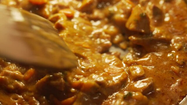 Close up of stewing beef and vegetables goulash in a pan. Concept of cooking tasty food.