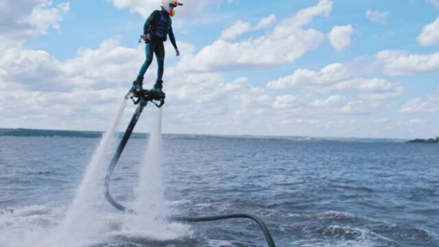 A man flying above the river on the flyboard