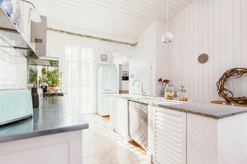 Bright wooden rustic kitchen with white furniture, big window and fridge