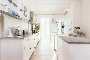 Fototapeta na wymiar Bright white open ln kitchen interior in stylish home for single family