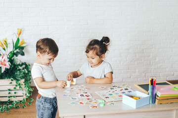 Boy and girl play educational games on the table