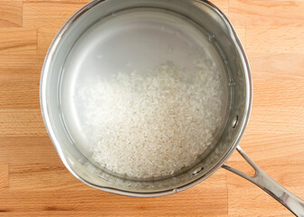Washed rice lies in a bowl in water